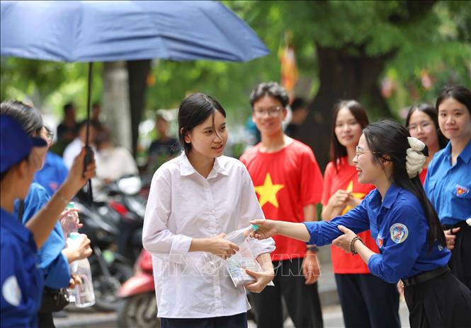 Thí sinh nhận nước uống miễn phí tại điểm thi Trường THPT Trần Nhân Tông. Ảnh: Thanh Tùng - TTXVN